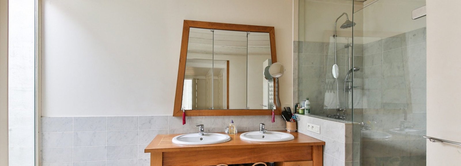 A beautiful wood vanity bathroom with frameless shower door enclosure