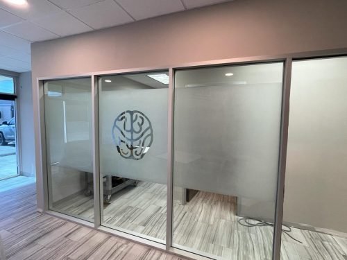 AFTER: Glass Partition Wall with Sliding Door and Etched Logo — Houston TX