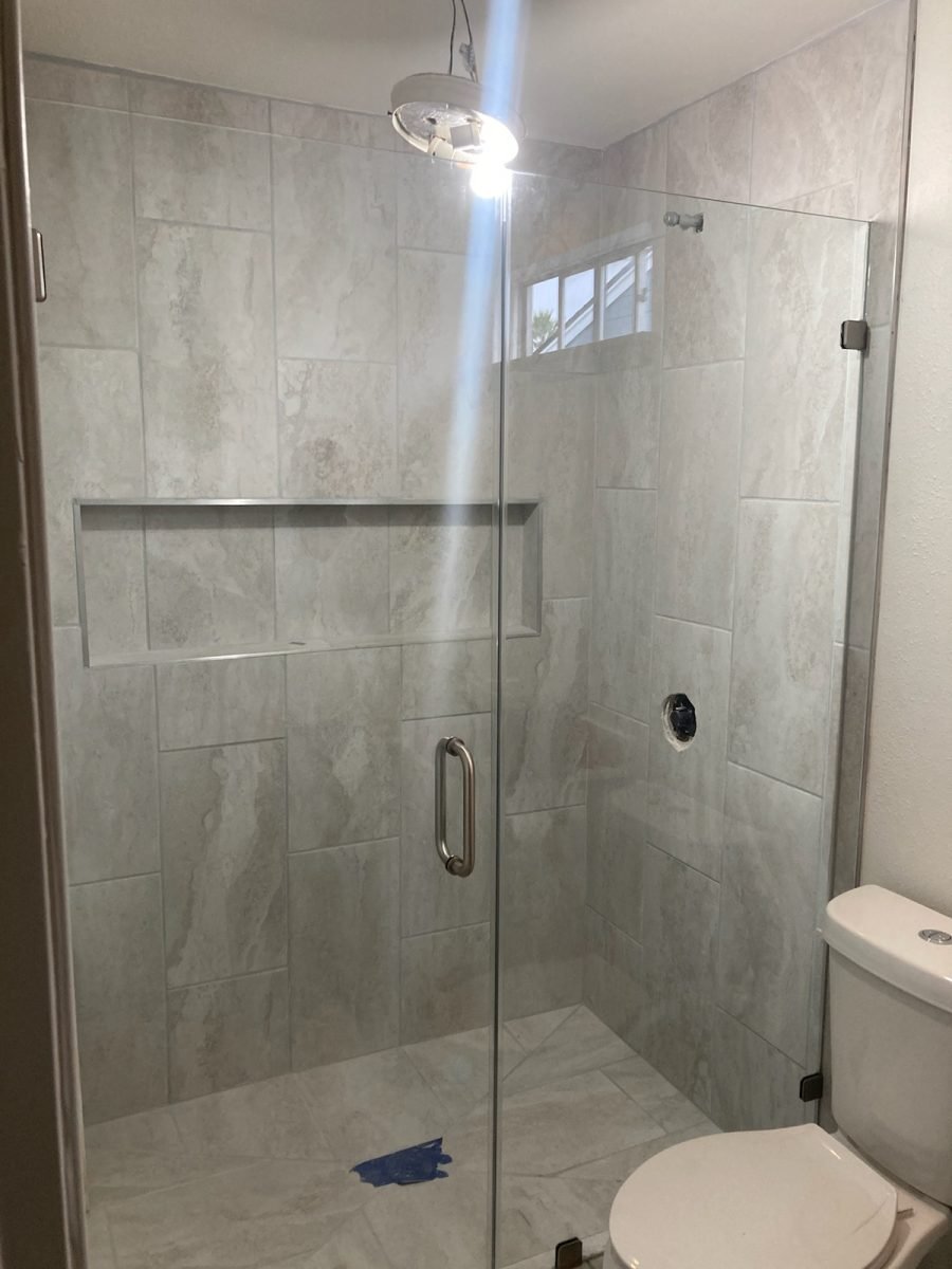 Tub-to-shower conversion with frameless door and panel, tiled niche and window, Houston TX